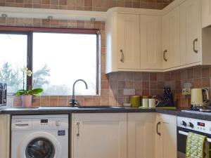 a kitchen with a sink and a dishwasher at Harwood Dale Cottage in Kendal