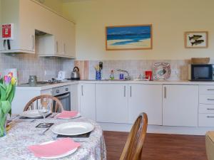 a kitchen with a table and chairs and a kitchen with white cabinets at Quartermasters in Brancepeth