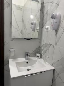 a white bathroom with a sink and a mirror at Ca Aisha Train Station Venice in Mestre