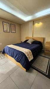 a bedroom with a large bed with a blue blanket at A23 Premium Suite WHITE Cocina Terraza Companies Work Teams 1-2 PAX in Cuautitlán Izcalli