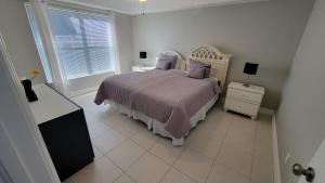 ein weißes Schlafzimmer mit einem Bett und einem Fenster in der Unterkunft SW Florida Waterfront Home in Cape Coral + 32 Fotos