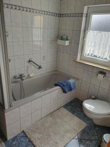 a bathroom with a tub and a toilet at Wünschel Stube in Gossersweiler-Stein +29 photos