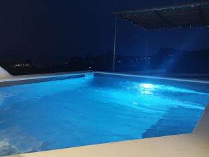 a swimming pool at night with a view at Filia Bungalow in Archangelos