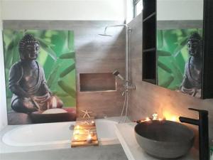 a bathroom with a sink and a bath tub with aificantificantificantificantificant at Getaway to Mauritius - Évasion à Île Maurice in Eau Bleue