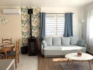 a living room with a couch and a table at Le petit coin de la Haute Somme in Hem-Monacu