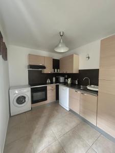 a kitchen with a washing machine and a washer at Au petit bonheur in Gorze