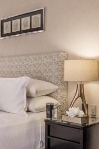 a bedroom with a bed with a lamp and a side table at Artesana - Privately Owned Rosewood Residence in San Miguel de Allende