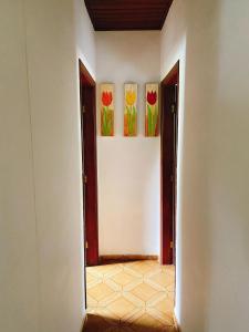 two paintings of flowers on a wall in a room at Sítio Pand'Oro in Atibaia