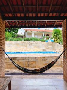 a hammock on a brick wall next to a pool at Sítio Pand'Oro in Atibaia