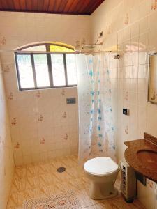 a bathroom with a toilet and a sink and a window at Sítio Pand'Oro in Atibaia