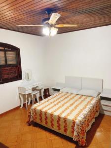 a bedroom with a bed and a desk and a ceiling at Sítio Pand'Oro in Atibaia