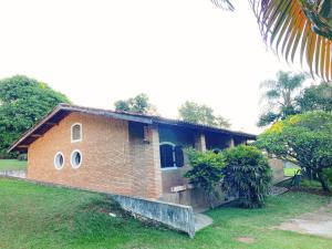 a brick house with round windows in a yard at Sítio Pand'Oro in Atibaia