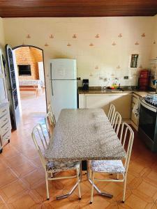 a kitchen with a table and chairs and a refrigerator at Sítio Pand'Oro in Atibaia