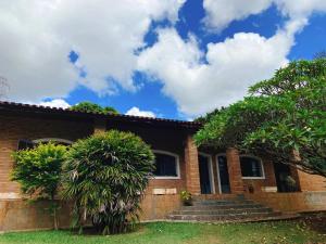a brick house with palm trees in front of it at Sítio Pand'Oro in Atibaia
