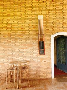 a table and chairs next to a brick wall at Sítio Pand'Oro in Atibaia