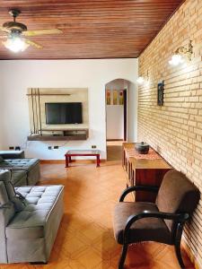 a living room with a couch and a tv at Sítio Pand'Oro in Atibaia
