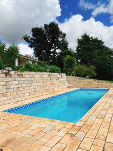 a swimming pool next to a brick wall at Sítio Pand'Oro in Atibaia