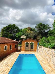 a swimming pool in front of a house at Sítio Pand'Oro in Atibaia
