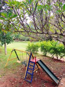 a swing set in a park with a tree at Sítio Pand'Oro in Atibaia
