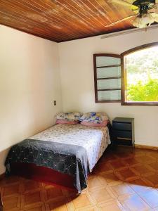 a bedroom with a bed and a window at Sítio Pand'Oro in Atibaia