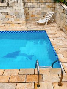 a swimming pool with a chair next to it at Sítio Pand'Oro in Atibaia