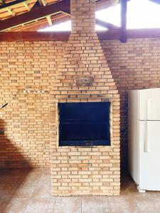 a brick fireplace in a brick wall with a refrigerator at Sítio Pand'Oro in Atibaia +24 photos