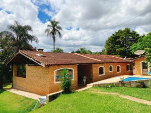a small house with a swimming pool in a yard at Sítio Pand'Oro in Atibaia