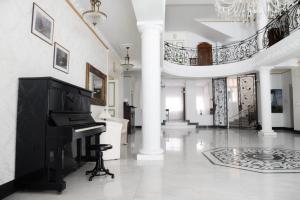 a piano in a white room with a staircase at Hotel Jardin in Belgrade