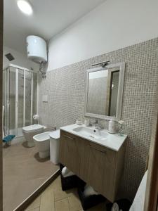 a bathroom with a sink and a toilet and a mirror at Mare Apartment 4 in Scalea +34 photos