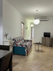 ein Wohnzimmer mit Sofa und Fernseher in der Unterkunft Mare Apartment 4 in Scalea