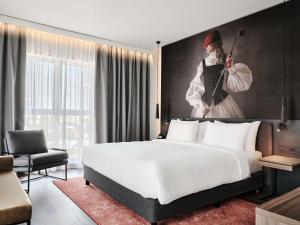 クラクフにあるRadisson RED Hotel & Radisson RED Apartments, Krakówの白い大型ベッドと女性の絵画が備わるベッドルーム1室 +37枚の写真