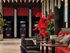 クラクフにあるRadisson RED Hotel & Radisson RED Apartments, Krakówの赤い彫刻が飾られたロビー(ソファ、テーブル付)
