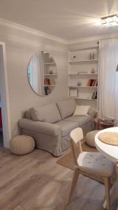 a living room with a couch and a mirror at Apartament nad Zalewem All-Inclusive in Serock