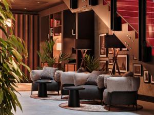 クラクフにあるRadisson RED Hotel & Radisson RED Apartments, Krakówのソファ、テーブル、植物のあるロビー