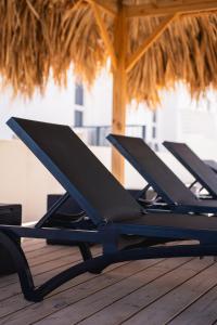 a row of black lounge chairs on a deck at 'Casa 30' Villa nearby Mambo-Beach in Willemstad