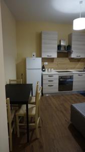 a kitchen and dining room with a table and a refrigerator at La Fara Apartment in Benevento