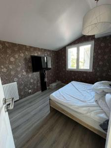 a bedroom with a bed and a flat screen tv at Villa contemporaine avec piscine in Romans-sur-Isère +14 photos