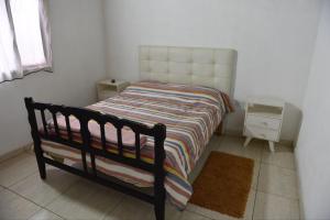 a small bedroom with a bed and a night stand at Casa con Piscina y Parrilla in Timbues +7 photos