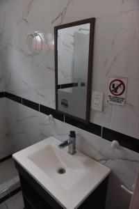 a bathroom with a white sink and a mirror at Casa con Piscina y Parrilla in Timbues