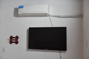 a flat screen tv hanging on a wall at Casa con Piscina y Parrilla in Timbues