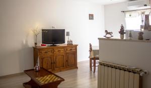 a living room with a tv on a wooden cabinet at La casa di Belle in Castelchiodato