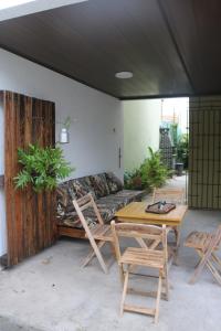 a patio with a couch and a table and chairs at A casa do lago in Aracaju