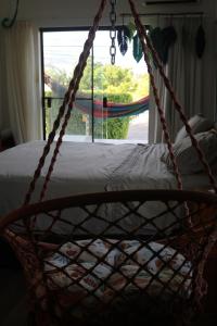 a rope swing in a bedroom with a window at A casa do lago in Aracaju