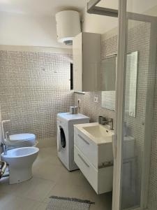 a bathroom with a toilet a sink and a washing machine at Mare Apartment 4 in Scalea +58 photos