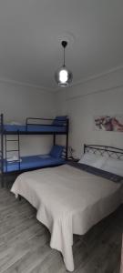 a bedroom with a bed and two bunk beds at Victoria Loutraki Лутраки apartment in Loutraki