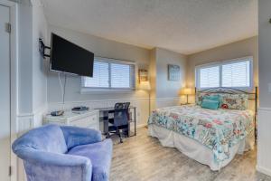 a bedroom with a bed and a chair and a tv at Plantation Dunes #5801 in Gulf Highlands +19 photos