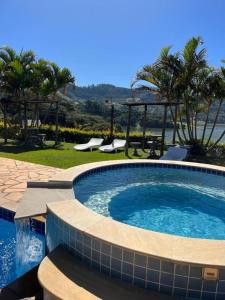 a large swimming pool with a view of the ocean at Chalé Represa Suite Varanda Do Sol in Joanópolis +51 photos