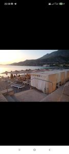 a picture of a beach with umbrellas and the sunset at Victoria Loutraki Лутраки apartment in Loutraki +15 photos
