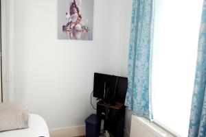 a bedroom with a bed and a window at Spacious 4-Bed House - Sleeps 5 Garden & Parking in London
