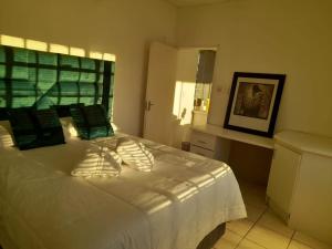 a bedroom with a large white bed with a window at Signature Guesthouse in Ventersburg